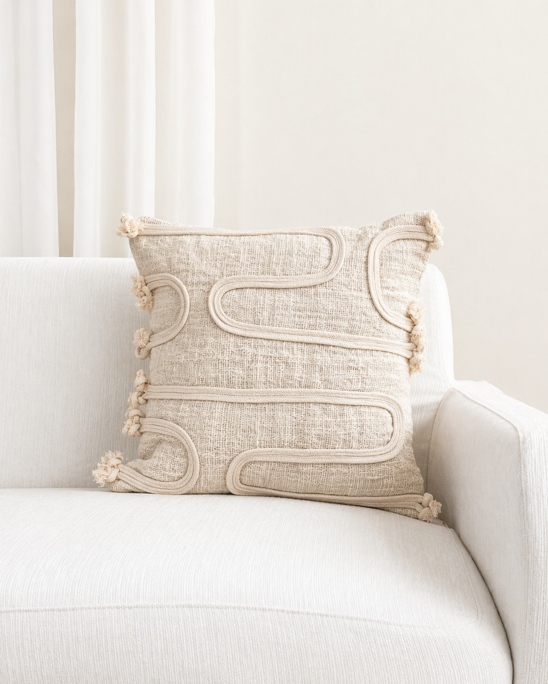 Decorative pillow with intricate patterns on a white sofa