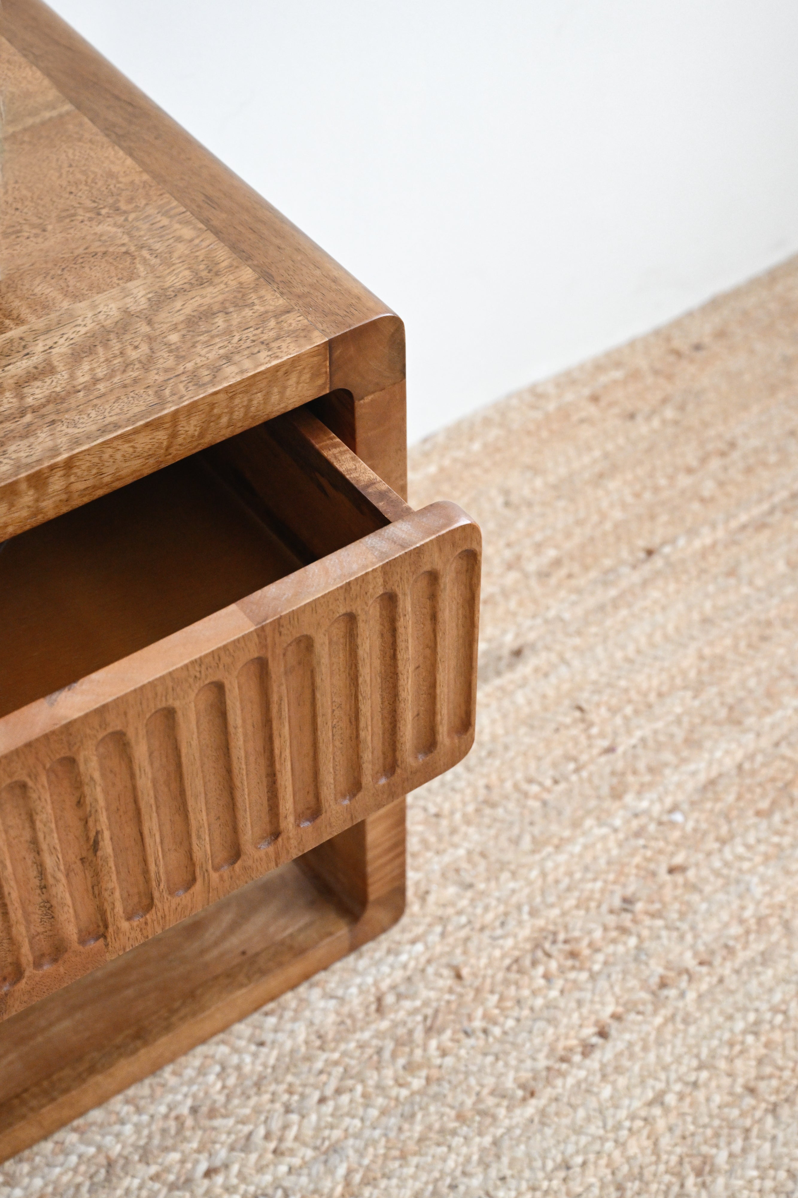 Wooden drawer unit on a textured surface with a neutral background