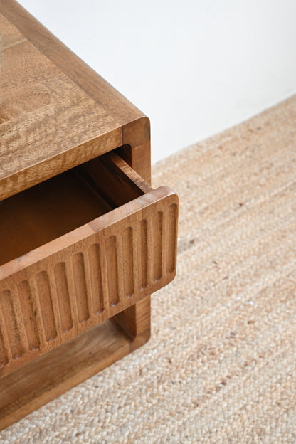 Wooden drawer unit on a textured surface with a neutral background