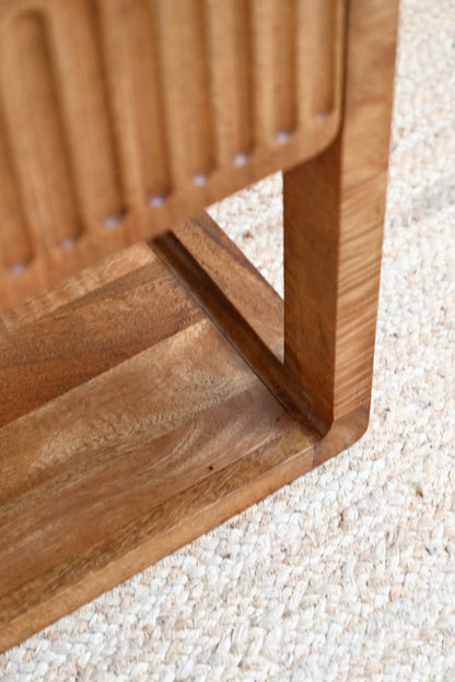 Close-up of a wooden chair corner on a textured surface