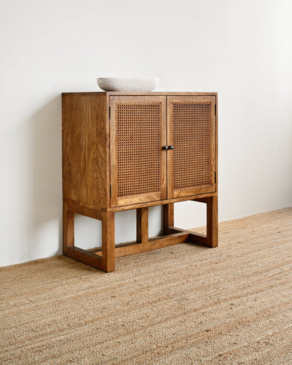 Wooden cabinet with wicker doors on a neutral background