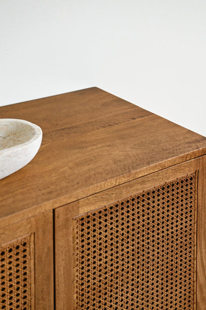 Wooden cabinet with wicker detailing on a white background