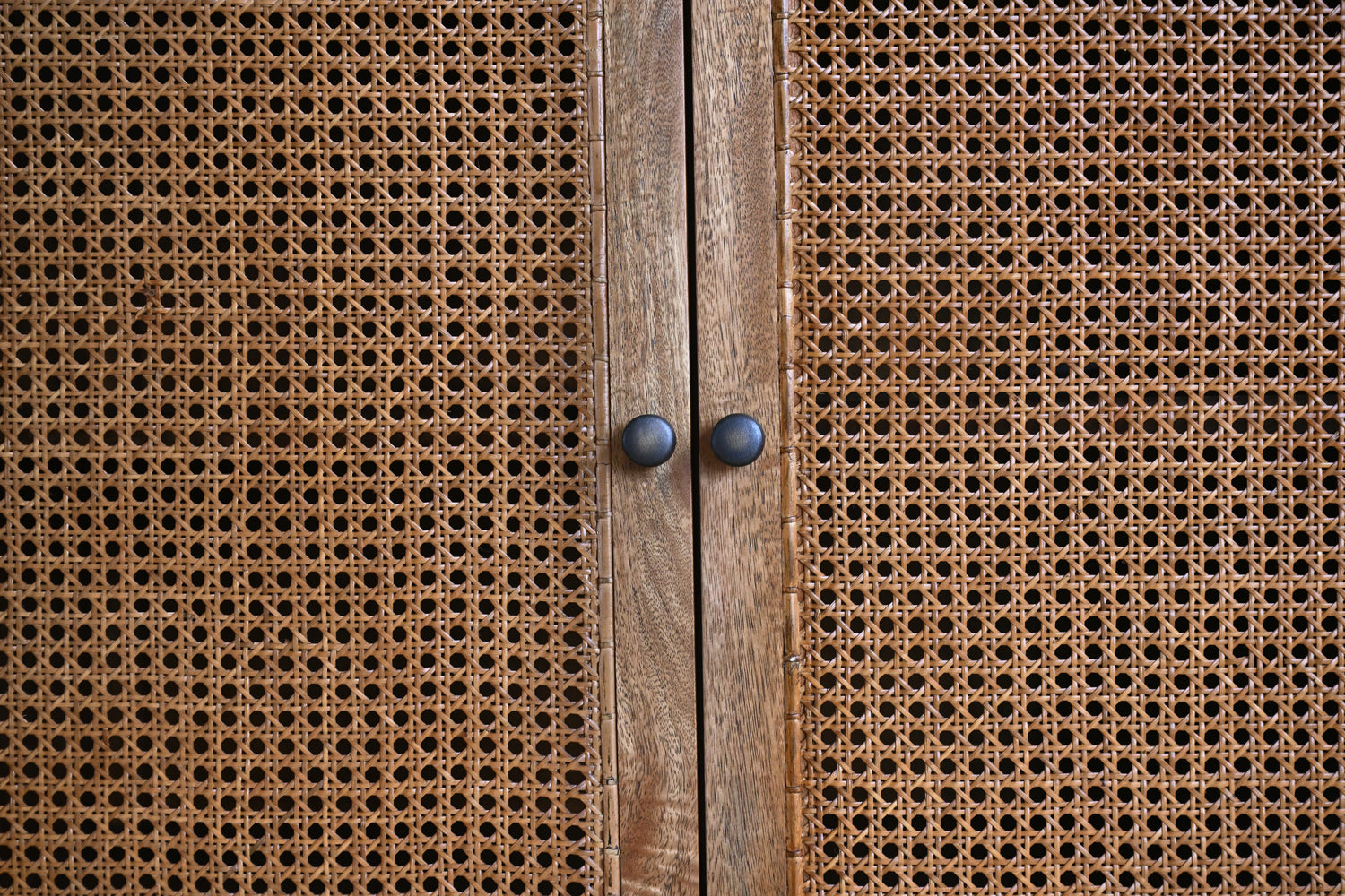 Close-up of a wooden cabinet with rattan doors.