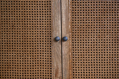 Close-up of a wooden cabinet with rattan doors.
