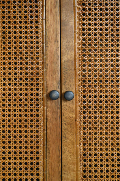 Close-up of a wooden cabinet with wicker doors and metal handles.