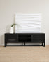 Black TV stand with a white abstract wall art piece in a minimalistic room.