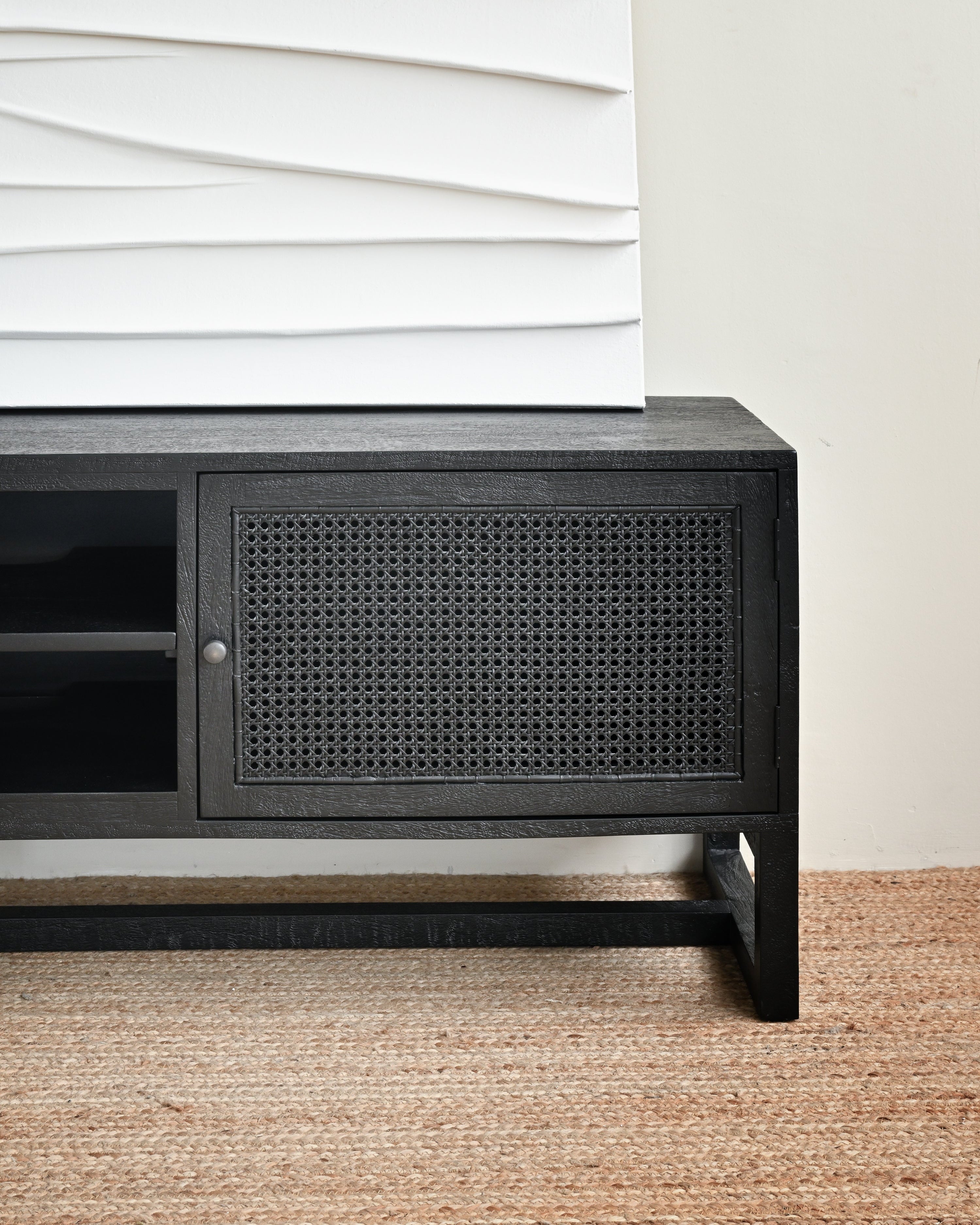 Black cabinet with wicker door on a beige carpet