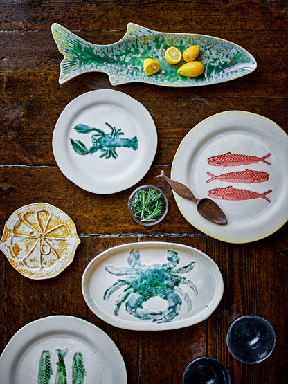 Collection of ceramic plates with animal designs on a wooden surface