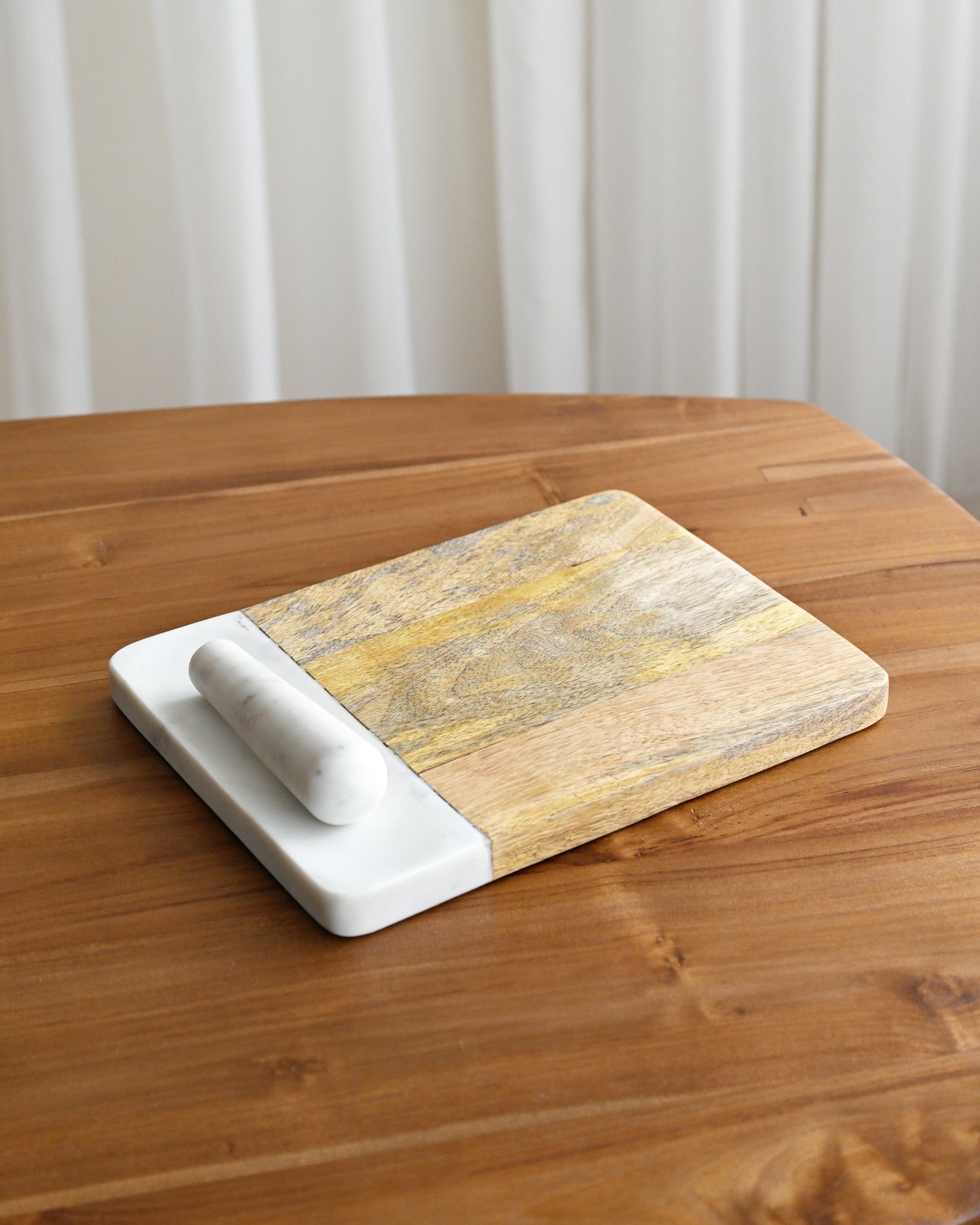 Marble-patterned cutting board with white base on a wooden surface