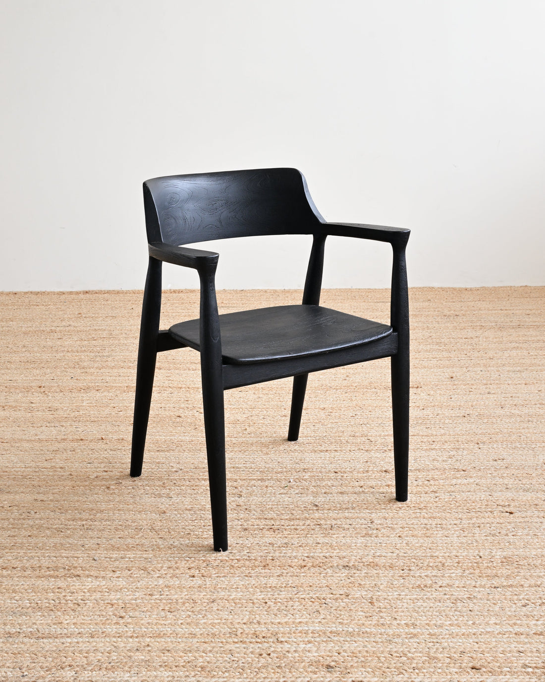 Black chair on a beige carpet with a white wall background