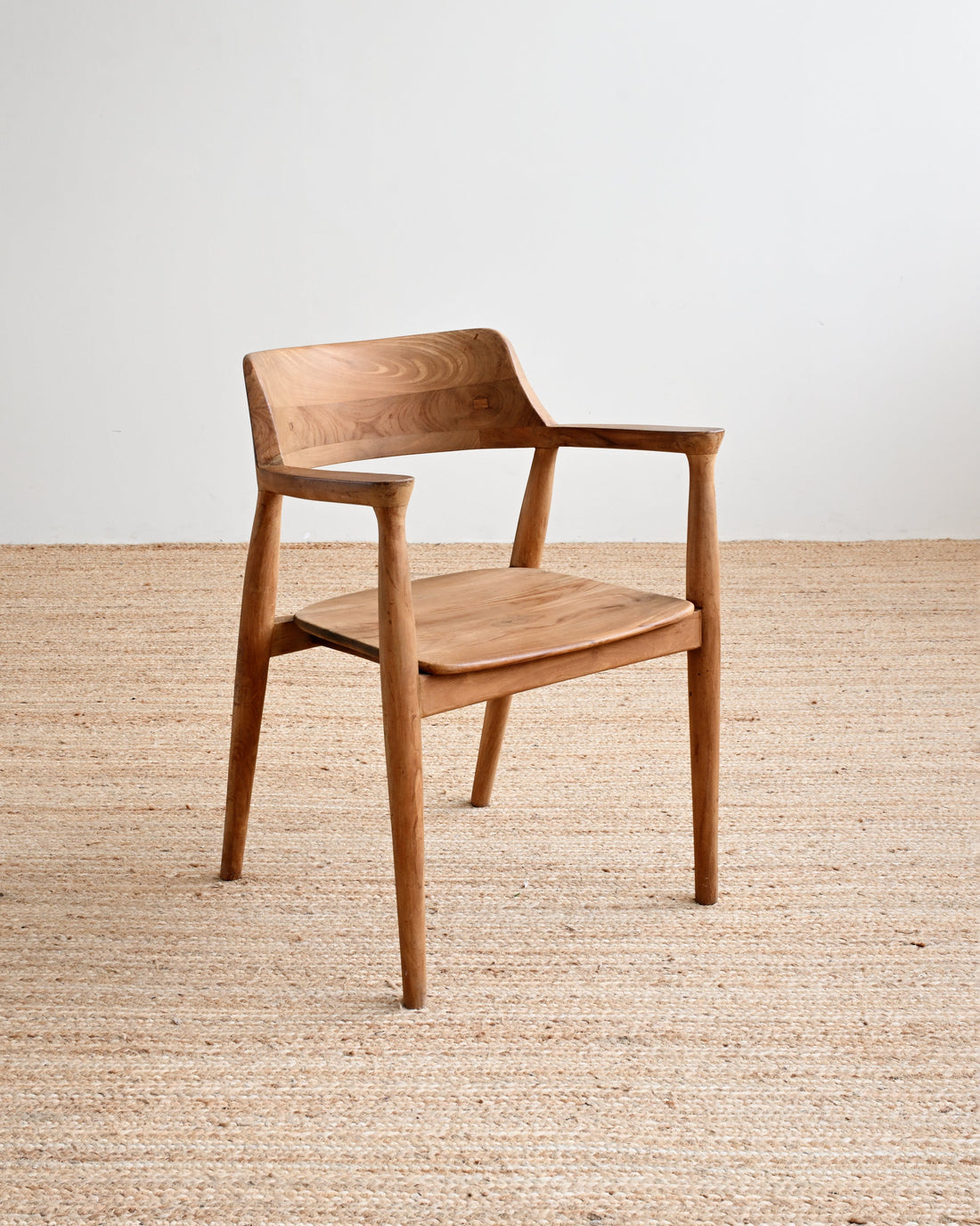 Wooden chair on a wooden floor with a white wall background