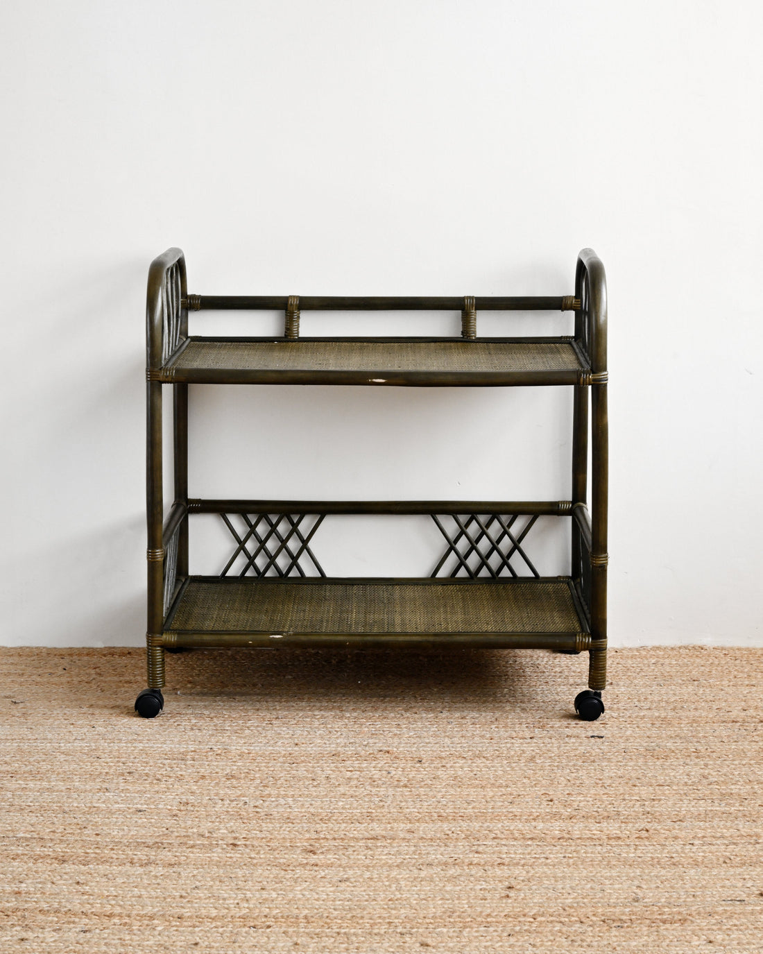 Vintage-style metal serving cart on a beige carpet with a white wall background
