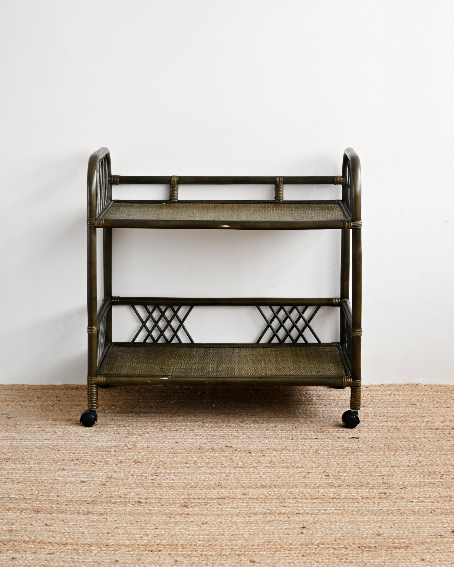 Vintage-style metal serving cart on a beige carpet with a white wall background