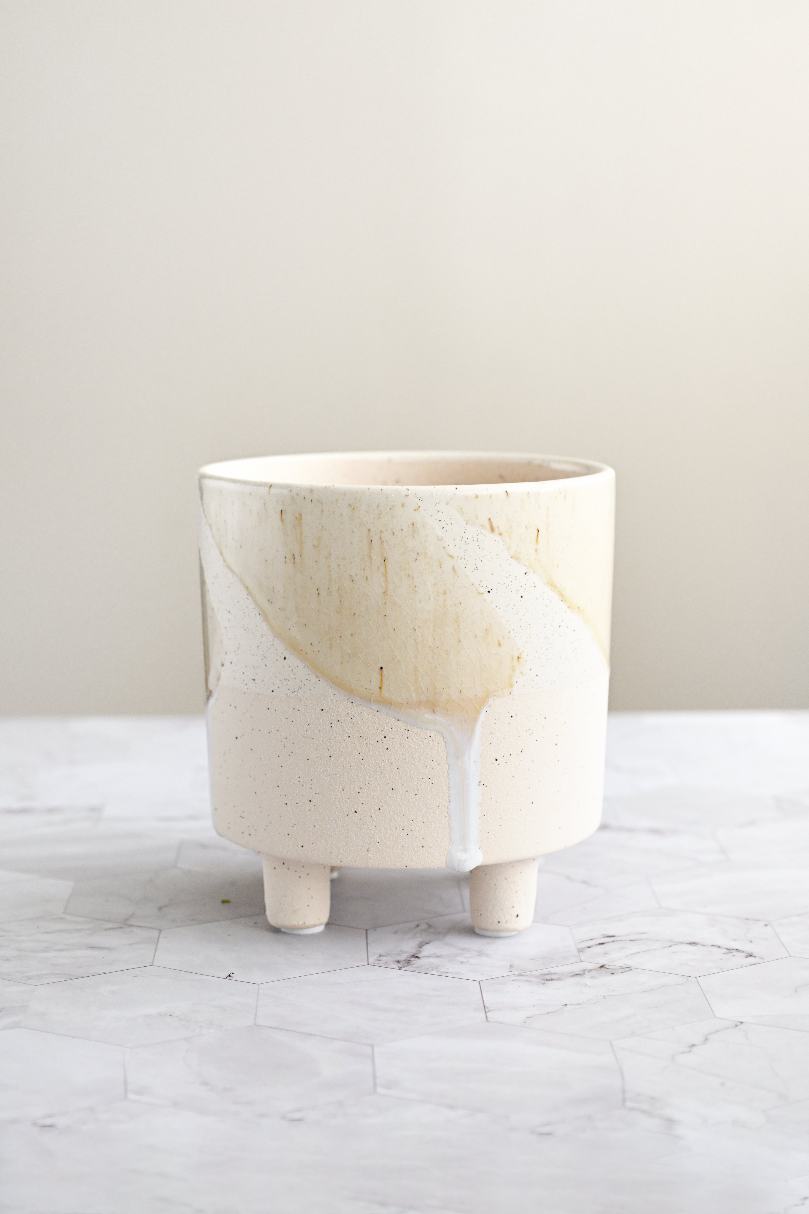 Ceramic planter with a natural wood top on a marble surface