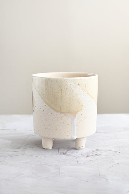 Ceramic planter with a natural wood top on a marble surface