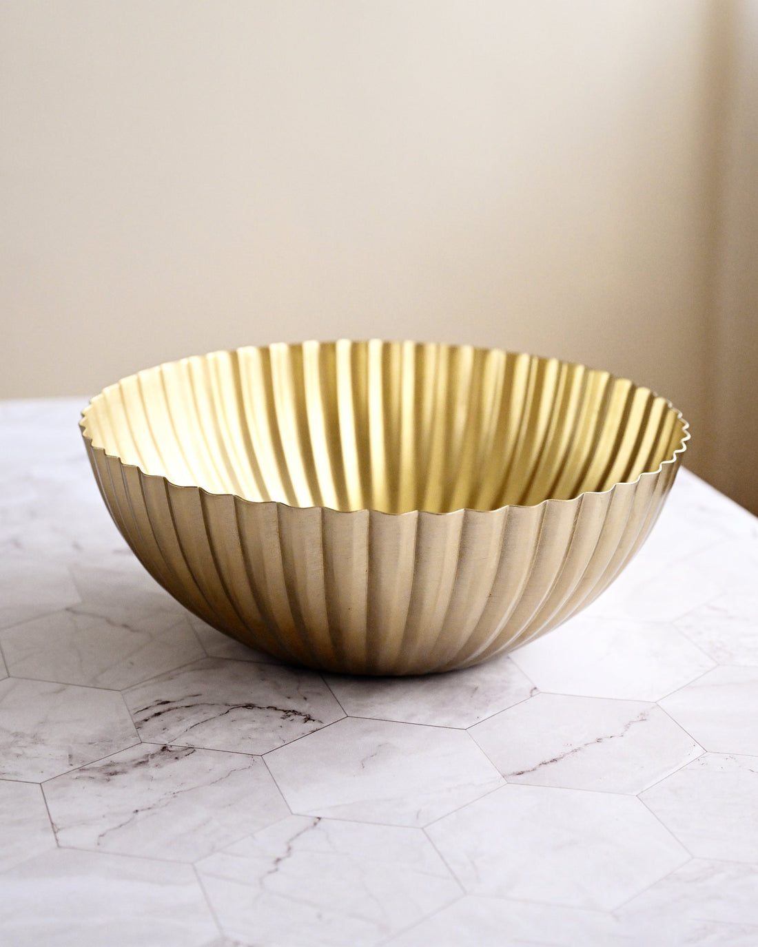 Gold decorative bowl on a marble surface with a neutral background