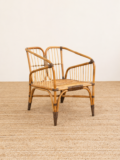 Wicker chair with black accents on a textured surface