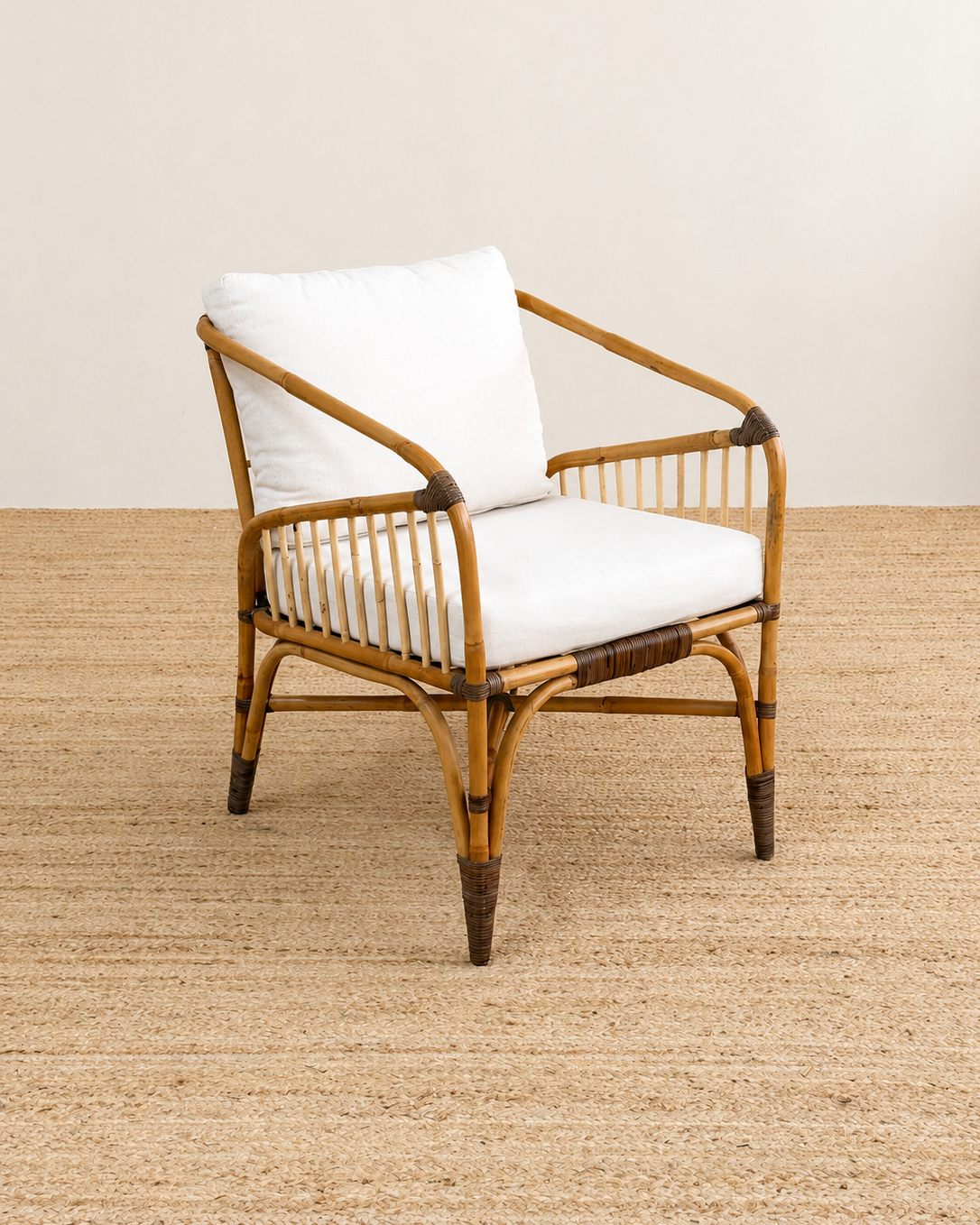 Rattan armchair with white cushion on a beige carpet