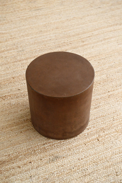 Brown cylindrical object on a textured beige surface