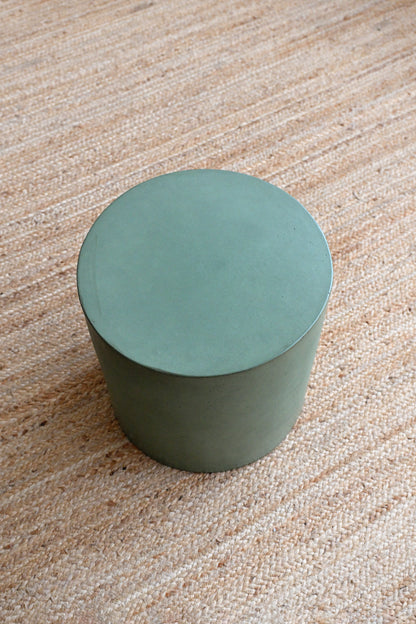 Green cylindrical object on a textured beige surface