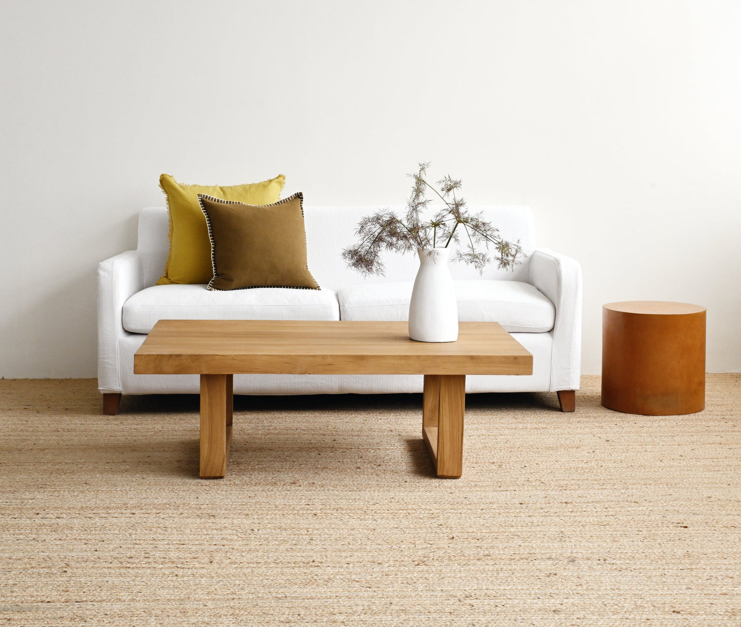 Modern living room with a white sofa, wooden coffee table, and decorative elements.