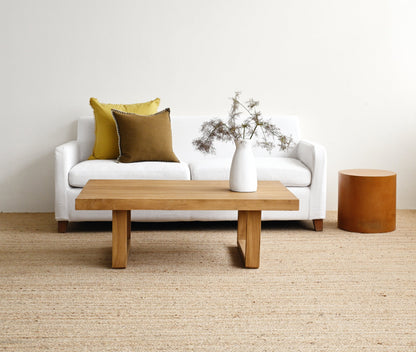 Modern living room with a white sofa, wooden coffee table, and decorative elements.