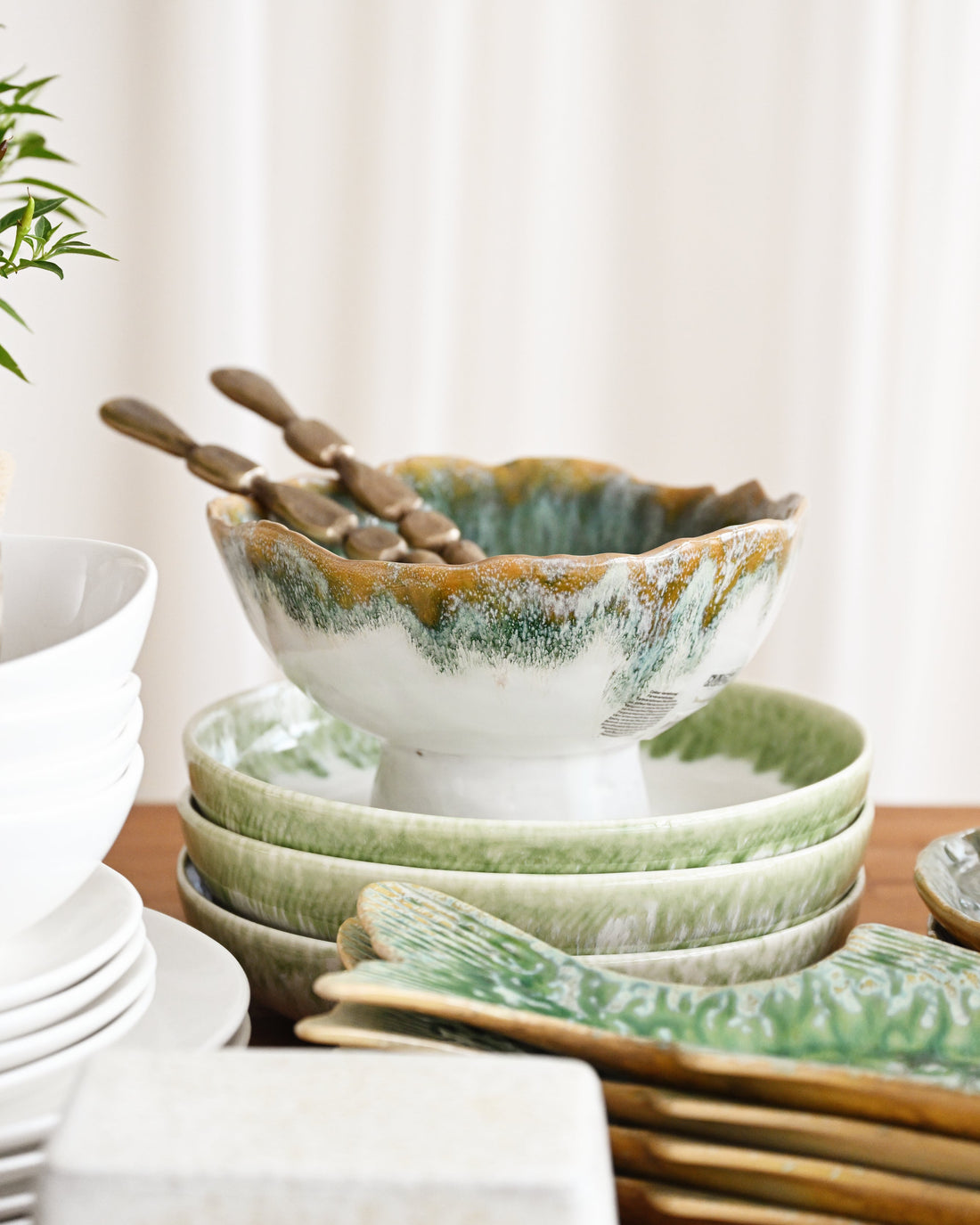 Set of ceramic bowls and plates on a wooden surface with a neutral background
