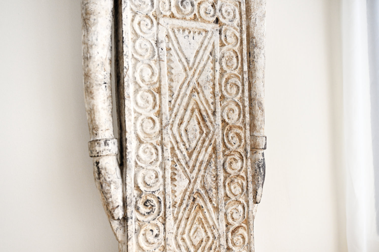 Decorative wooden panel with intricate carvings on a white background