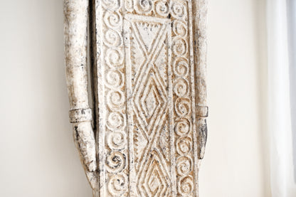Decorative wooden panel with intricate carvings on a white background