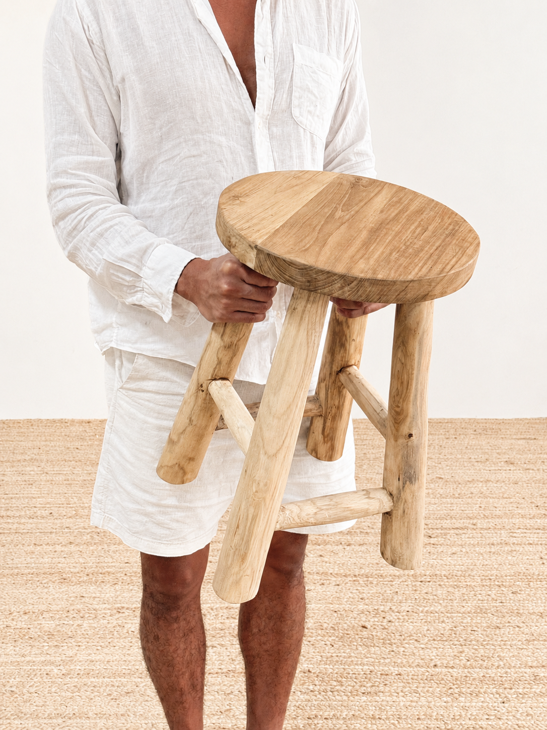 Person holding a wooden stool against a plain background