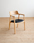 Wooden chair with a black seat on a beige carpet