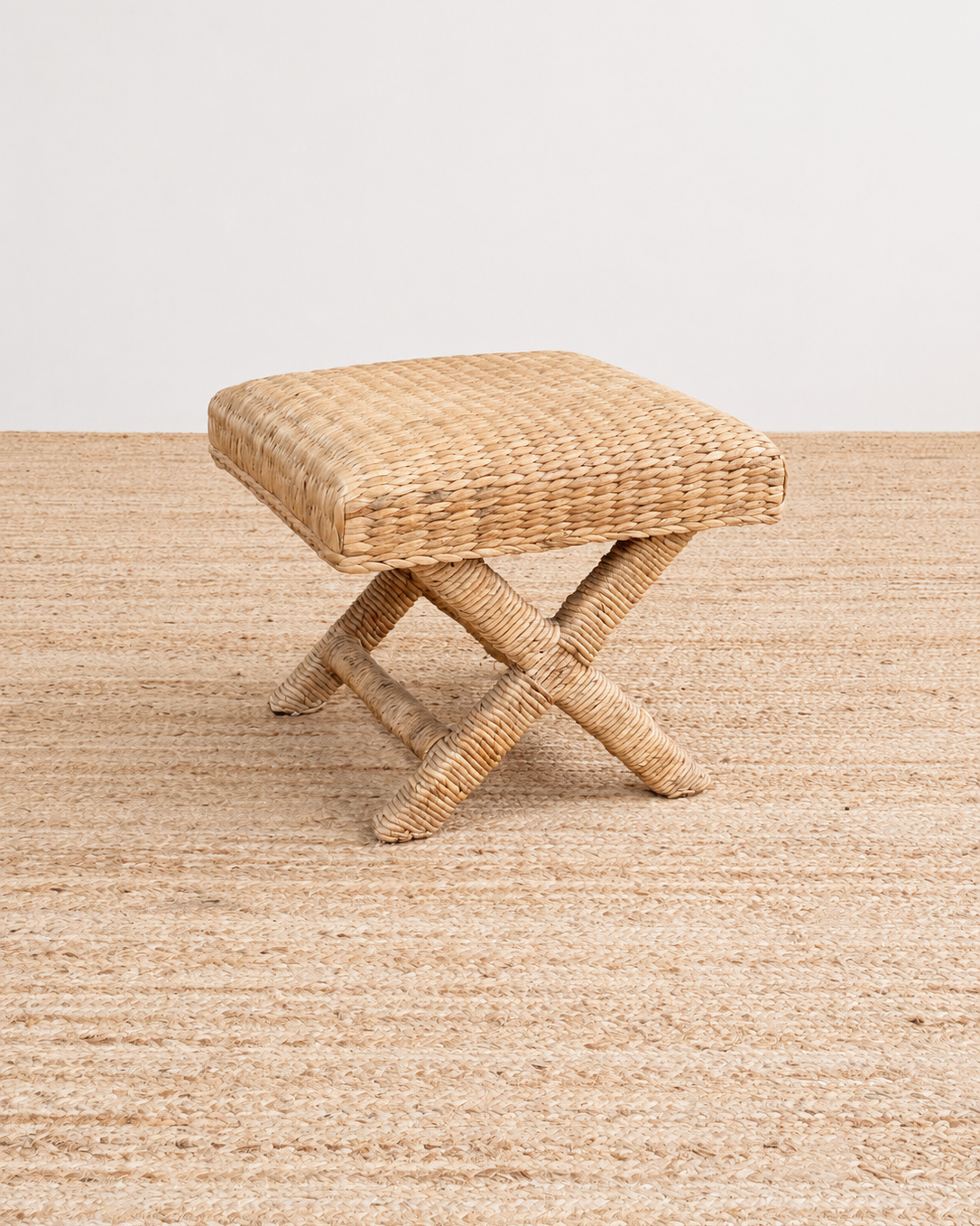 Woven stool on a textured surface with a neutral background