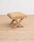 Woven stool on a textured surface with a neutral background