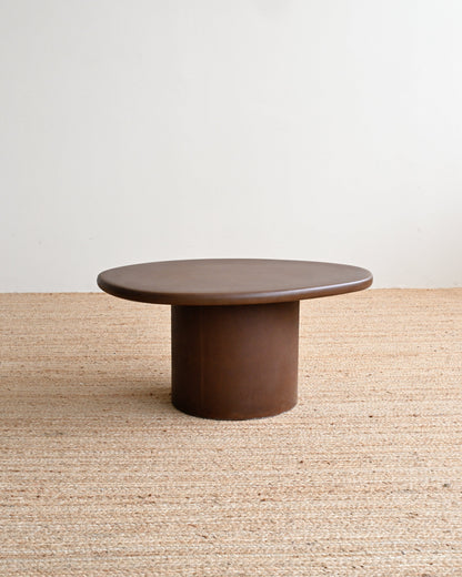 Brown coffee table on a textured beige surface with a light gray background