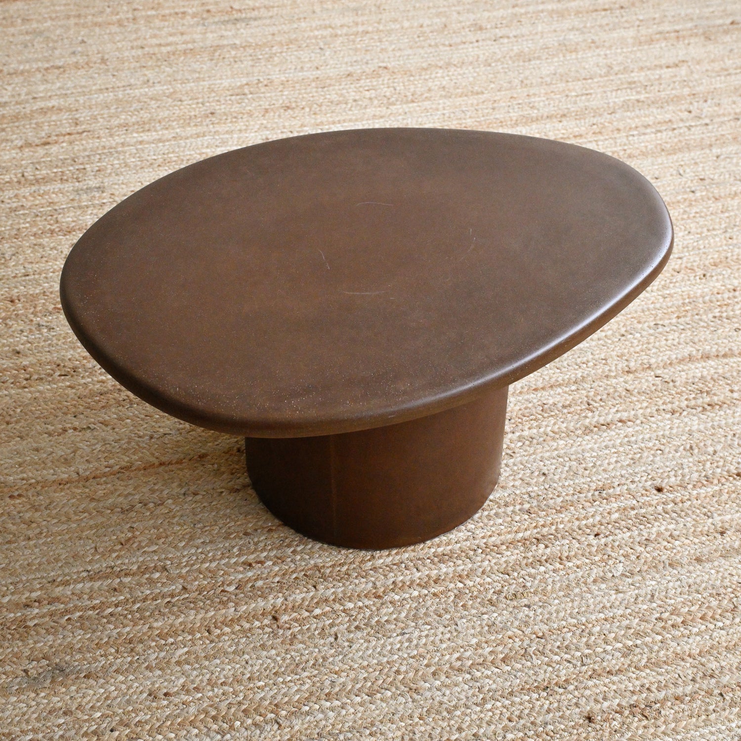 Brown ceramic table on a textured beige surface