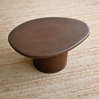 Brown ceramic table on a textured beige surface