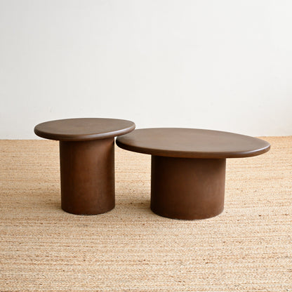 Two brown round tables on a textured surface with a neutral background