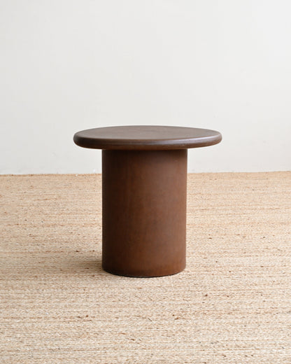 Round brown table on a textured surface with a neutral background