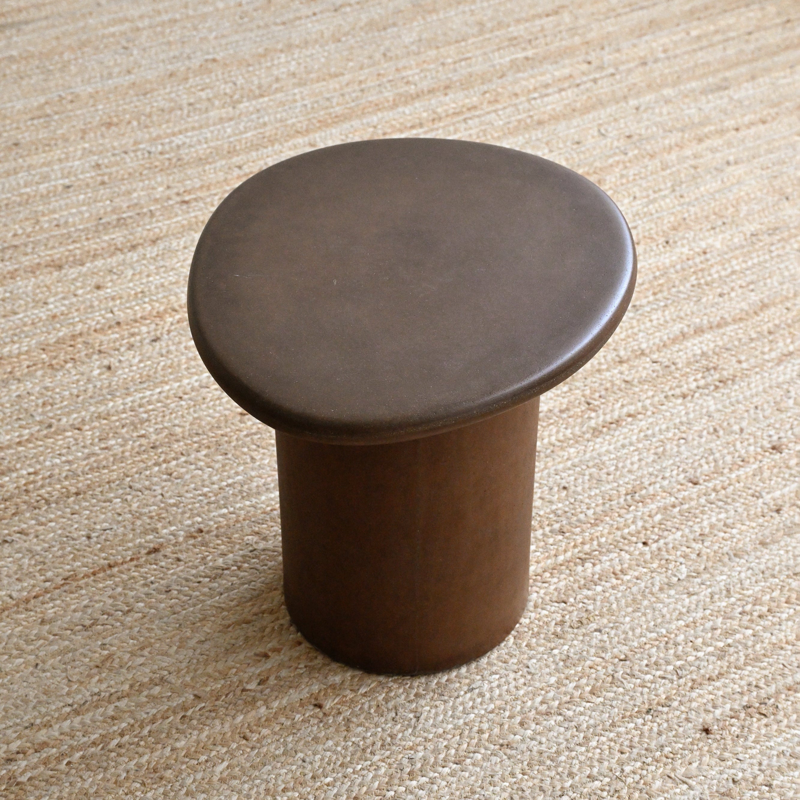Brown stool on a textured beige surface
