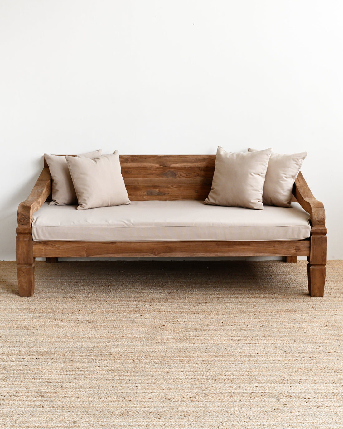 Wooden sofa with beige cushions on a plain white wall background
