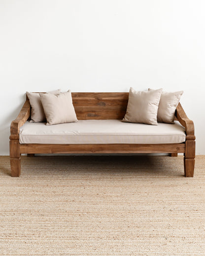Wooden sofa with beige cushions on a plain white wall background