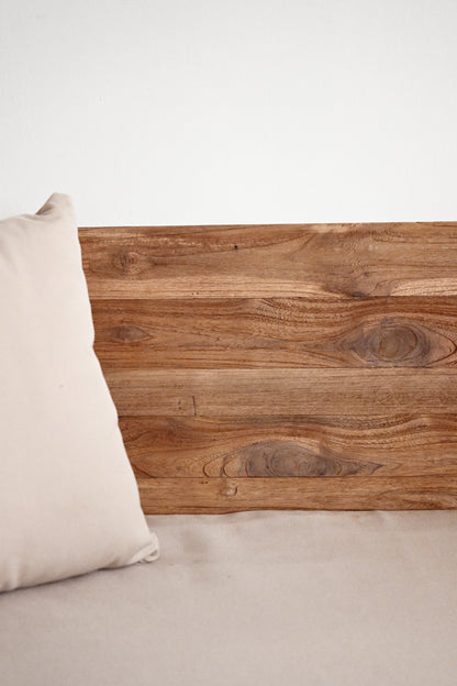 Wooden headboard with a pillow on a neutral background