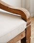 Wooden chair with beige cushion against a white curtain background