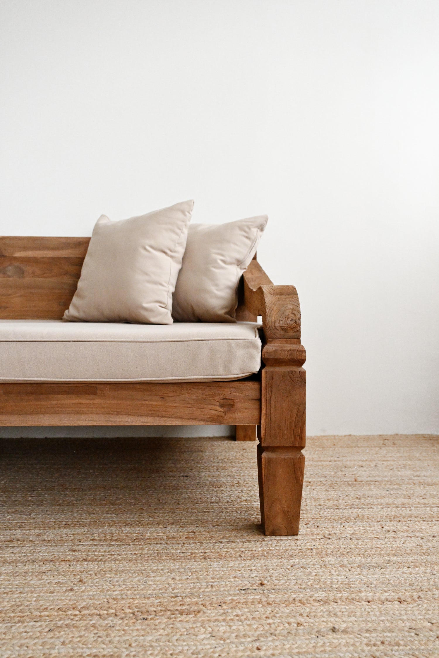 Wooden sofa with beige cushions on a neutral background