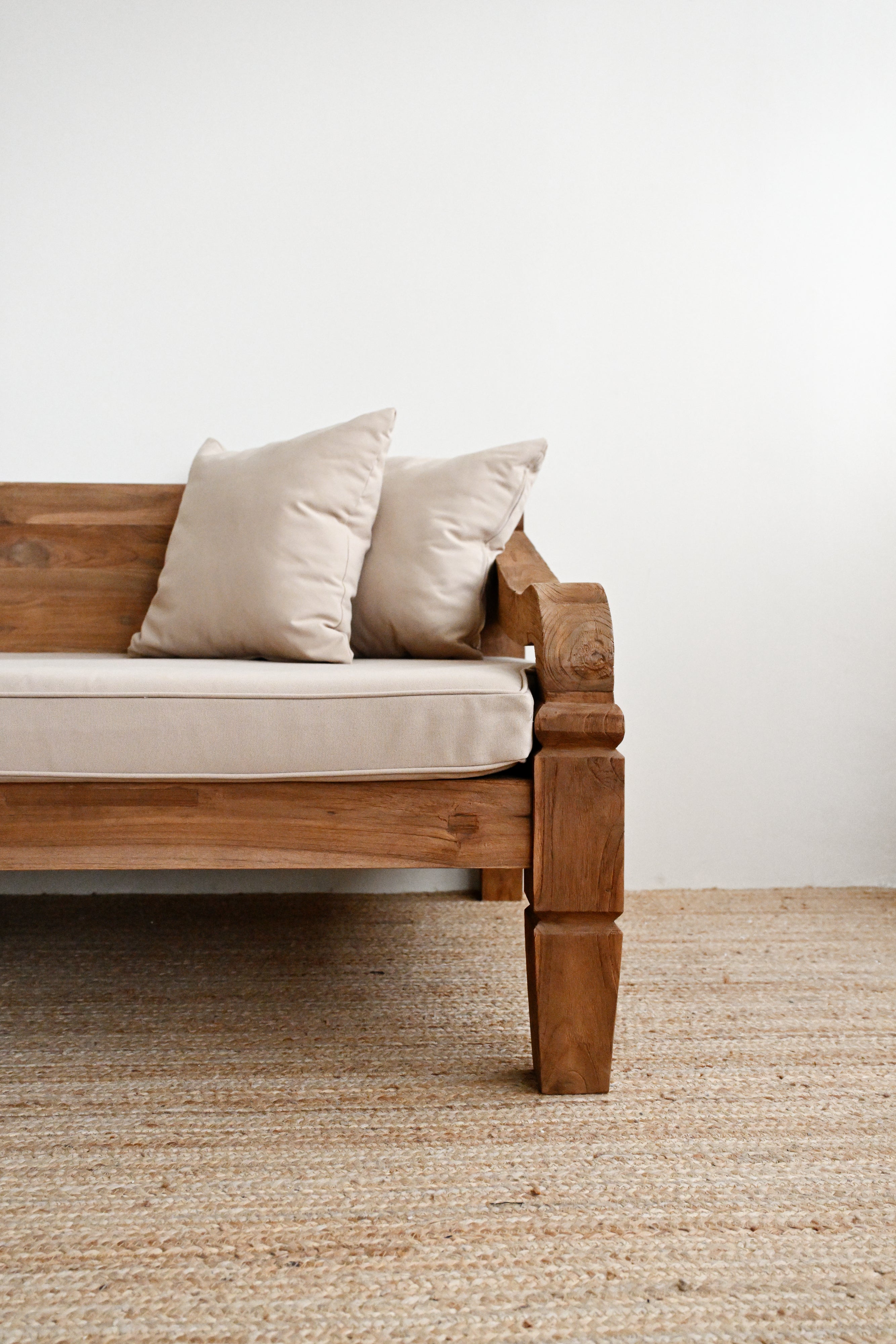 Wooden sofa with beige cushions on a neutral background