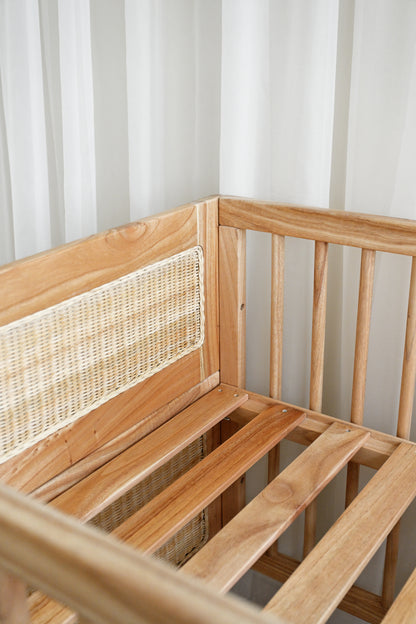 Wooden bench with woven backrest against a white curtain background