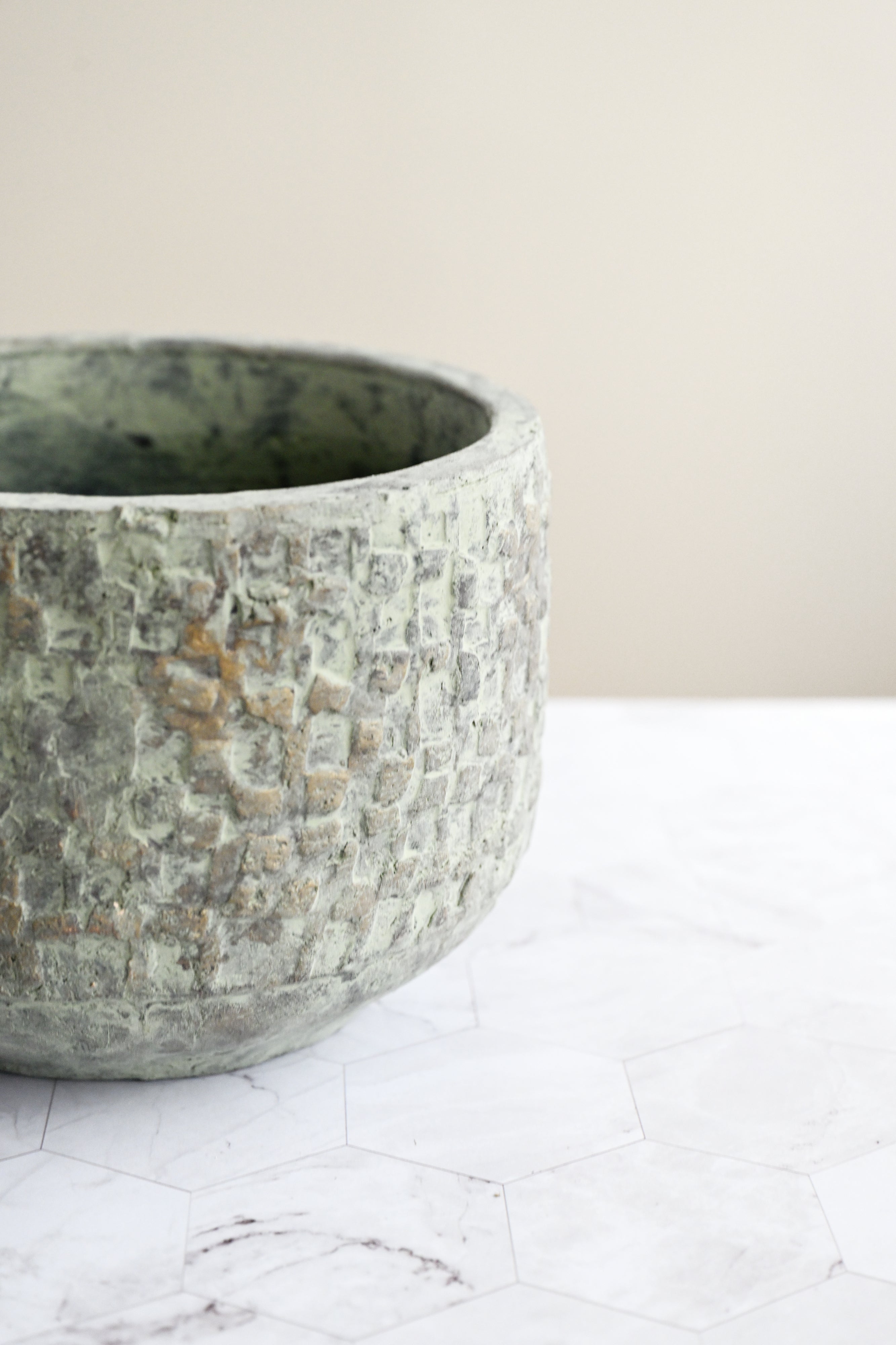 Textured stone bowl on a marble surface with a neutral background