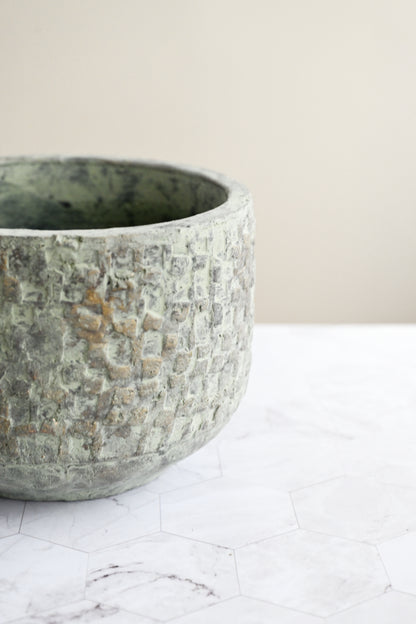 Textured stone bowl on a marble surface with a neutral background