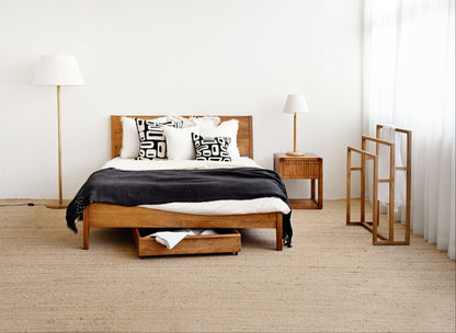 Modern bedroom with wooden bed, nightstands, and lamps.