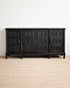 Black wooden sideboard with geometric design on a beige carpet and white wall